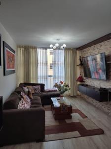 a living room with a couch and a tv at Dpto entero, 2do piso, ascensor, jacuzzi y cochera in Lima