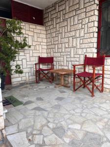 two red chairs and a table on a patio at Blue View Studio in Opatija