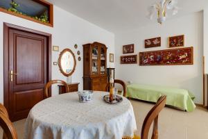 een kamer met een tafel en een klok en een slaapkamer bij Casa Vacanze Maria in Bosa