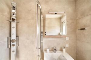 a bathroom with a sink and a shower with a mirror at Adele Apartment in Kissamos