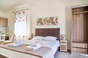 a bedroom with a large bed with towels on it at Adele Apartment in Kissamos