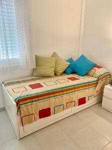 een slaapkamer met een bed met een kleurrijk dekbed en kussens bij Tramuntana apart in Calafell +15 foto's
