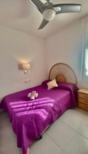 een slaapkamer met een paars bed en een paarse deken bij Tramuntana apart in Calafell