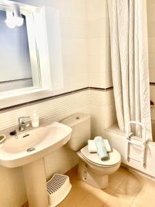 een witte badkamer met een wastafel en een toilet bij Tramuntana apart in Calafell