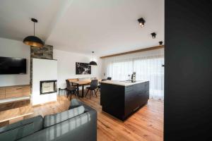 a kitchen and living room with a couch and a table at Hohe Tauern Lofts Panoramabahn by Alpina-Holiday in Dorf