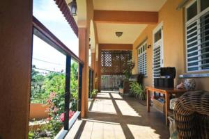 eine Veranda eines Hauses mit einer Terrasse in der Unterkunft Villa Coral Guesthouse in Vieques