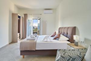 a bedroom with a large bed and a balcony at Bella Apartment in Kissamos