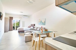 a kitchen and living room with a table and chairs at Bella Apartment in Kissamos