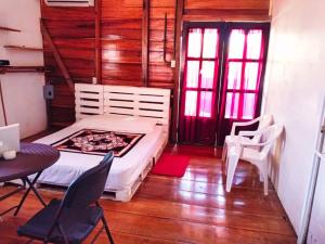 Schlafzimmer mit einem Bett, einem Tisch und Stühlen in der Unterkunft Poetry Garden Bocas Town Colon Island- Deluxe Bungalow Cabin-AC-Enjoy the Night Life in Bocas del Toro