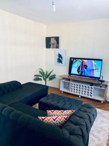 ein Wohnzimmer mit einem Sofa und einem Flachbild-TV in der Unterkunft CEECEE’S HAVEN in Paulo
