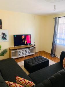 ein Wohnzimmer mit einem Sofa und einem Flachbild-TV in der Unterkunft CEECEE’S HAVEN in Paulo