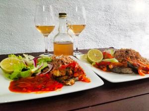 two plates of food and two glasses of wine at Poetry Garden Bocas Town Colon Island- Deluxe Bungalow Cabin-AC-Enjoy the Night Life in Bocas del Toro