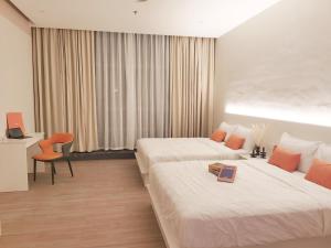 a hotel room with two beds and a chair at The Peak - Bangsar South Mid Valley in Kuala Lumpur