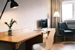a hotel room with a desk with a computer and a chair at Hotel Sturm Bio- & Wellnesshotel in der Rhön in Mellrichstadt