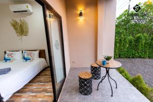 Habitación con cama, mesa y espejo. en Summer Sea Villa Khanom ซัมเมอร์ซีวิลล่า ขนอม en Ban Phang Phrao