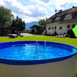 a large blue pool in a yard with a house at Oberwieserhof App 1 in San Lorenzo di Sebato