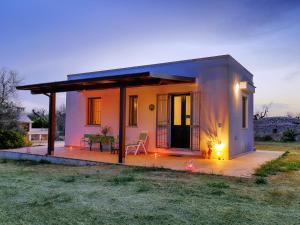 een klein huis met een patio in een veld bij Casa Barzò - surrounded by olive trees in Salve