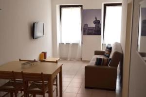 een woonkamer met een tafel en een bank bij Le Androne di Trento in Trento