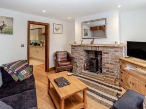 a living room with a couch and a fireplace at Fox Bank Cottage in Macclesfield