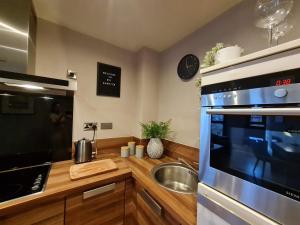 eine Küche mit Spüle und Herd oberen Backofen in der Unterkunft City Centre 2 Bedroomed Apartment - Great views - wifi in Sheffield
