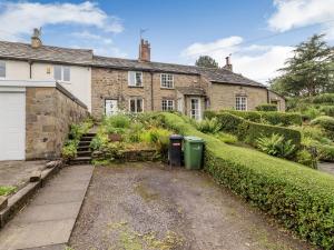 an old stone house with a garden in front of it at Fox Bank Cottage in Macclesfield