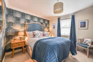 a bedroom with a bed with a blue blanket at Lisburne Place - Luxury Three Bedroom Town House in Torquay