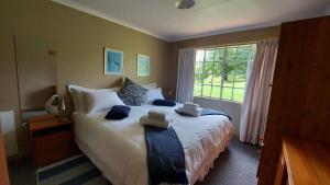 a bedroom with a large bed with towels on it at Apple Blossom Cottage in Dullstroom