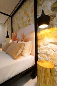 a bedroom with a bed and a stone wall at Estilo luxury apartment in Kavala