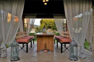 a patio with a table and chairs and curtains at Estilo luxury apartment in Kavála