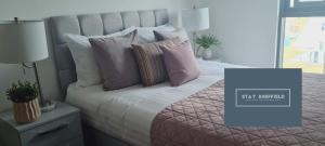 a bedroom with a bed with pink and white pillows at City Centre 2 Bedroomed Apartment - Great views - wifi in Sheffield