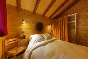 - une chambre avec un lit dans une pièce en bois dans l'établissement Chalet Anemone, à Soultzeren