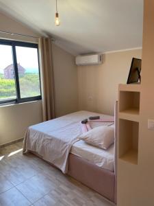 a small bedroom with a bed and a window at Hotel Ballkan Shkoder in Shkodër