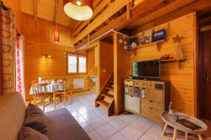 ein Wohnzimmer mit einem Sofa und einem TV in einer Hütte in der Unterkunft Chalet Anemone in Soultzeren