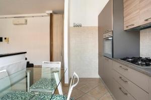 - une cuisine avec une table en verre et une cuisinière dans l'établissement Casti - Appartamento MM3 Comasina, à Milan