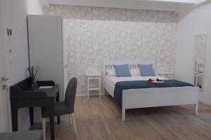 1 dormitorio con cama, escritorio y silla en B&B Il Giardino di Anto, en Pescara