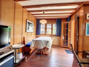 a dining room with a table and a television at Apartment Jacky 7 in Verbier