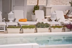 a group ofotted plants sitting next to a swimming pool at Relais Corte Palmieri & Il Chiostro - Residenza d'epoca in Gallipoli