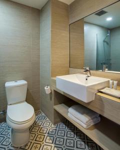 a bathroom with a white toilet and a sink at Rooms Inc BTC Bandung in Bandung