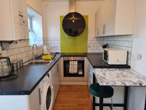 a kitchen with a sink and a stove top oven at The Grove House with Free Parking in Hull