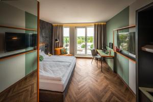 LOGINN Hotel Berlin Airport في برلين: غرفة في الفندق مع سرير ومكتب