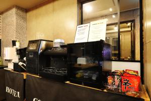 a kitchen counter with a microwave on top of it at Cornerstone Hotel in Seogwipo
