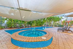 達爾文的住宿－By the Water Resort Style Lifestyle with Pool，一个带遮阳伞和热水浴池的游泳池