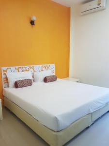 a bedroom with a large white bed with yellow walls at Life&Love Resort in Ban Khlong Son