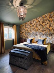 a bedroom with a bed and a chandelier at Sous Les Pins gîtes et chambres d'hôtes in La Londe-les-Maures
