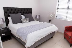 a bedroom with a large bed and a red chair at MLMK Property 30 in Richwood