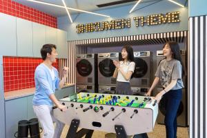 a group of people standing around a foosball table at lyf by Ascott Hongqiao Shanghai NECC in Shanghai
