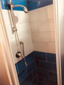 ナポリにあるDama HostelBBのシャワー、青と白のタイル張りのバスルーム