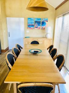 uma grande mesa de madeira com cadeiras num quarto em Mandurah Waterfront Retreat em Mandurah