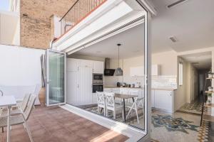 cocina y comedor con una gran puerta corredera de cristal en Macflats Ayuntamiento, en Valencia