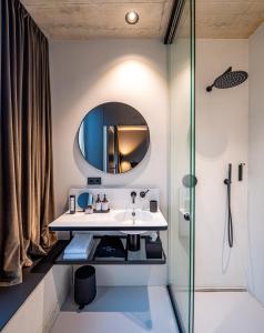 La salle de bains est pourvue d'un lavabo et d'un miroir. dans l'établissement Lifestyle B&B by Phillip Sigwart, à Brixlegg